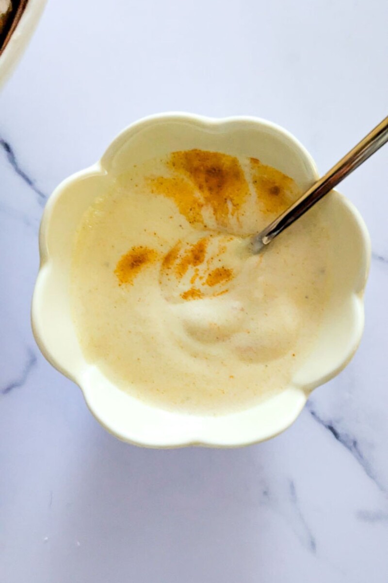 Turmeric and Greek yogurt salad dressing in a small bowl.