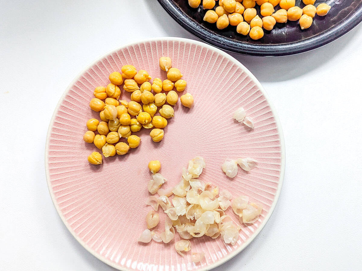 Peeled chickpeas and their skins on a plate.