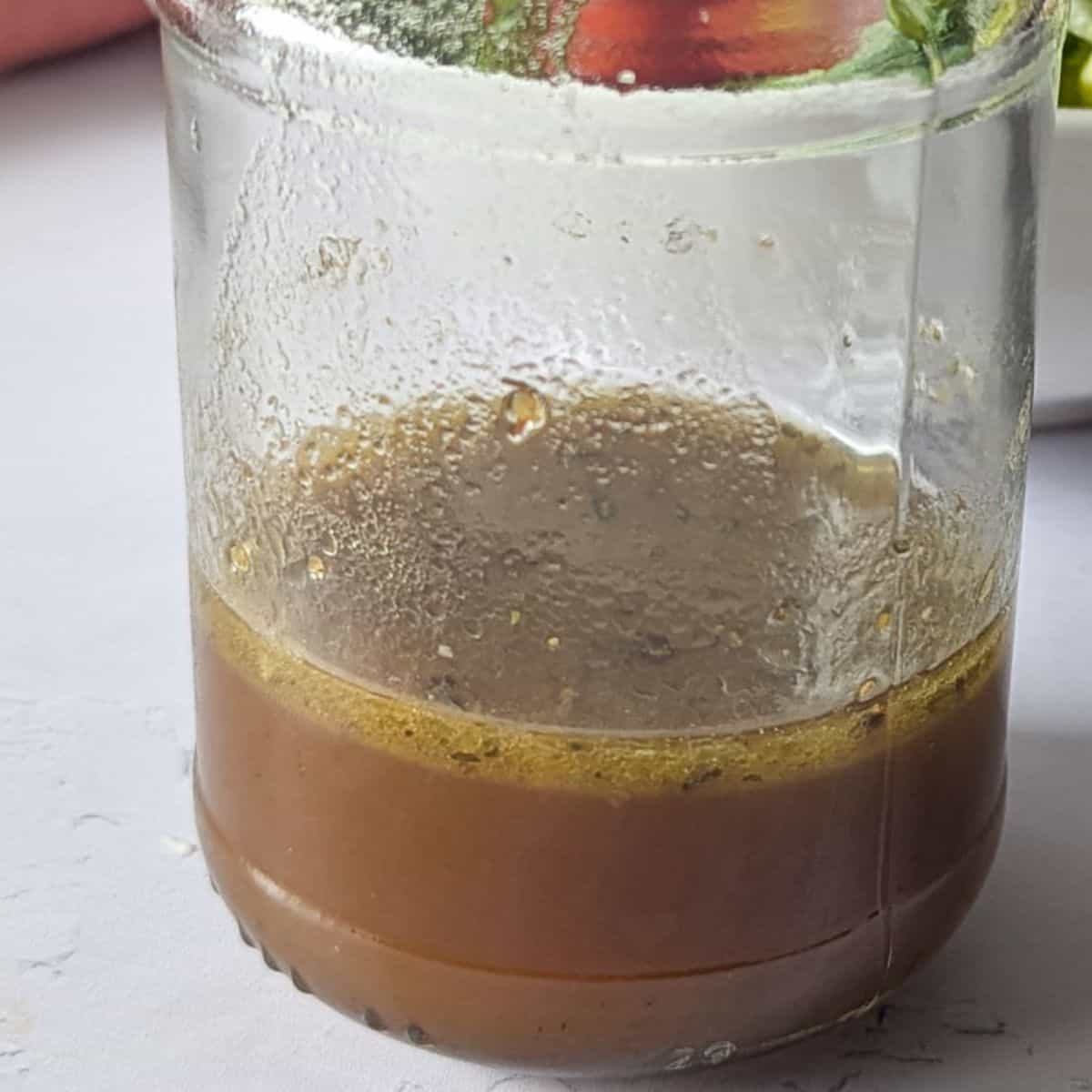 A zoomed in image of balsamic vinaigrette in a jar.