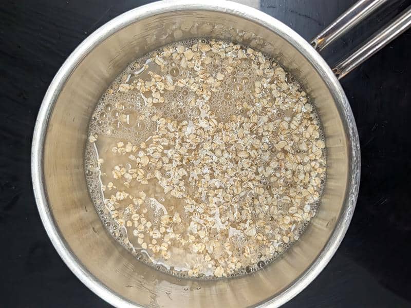 A saucepan showing oats just after water has been added.
