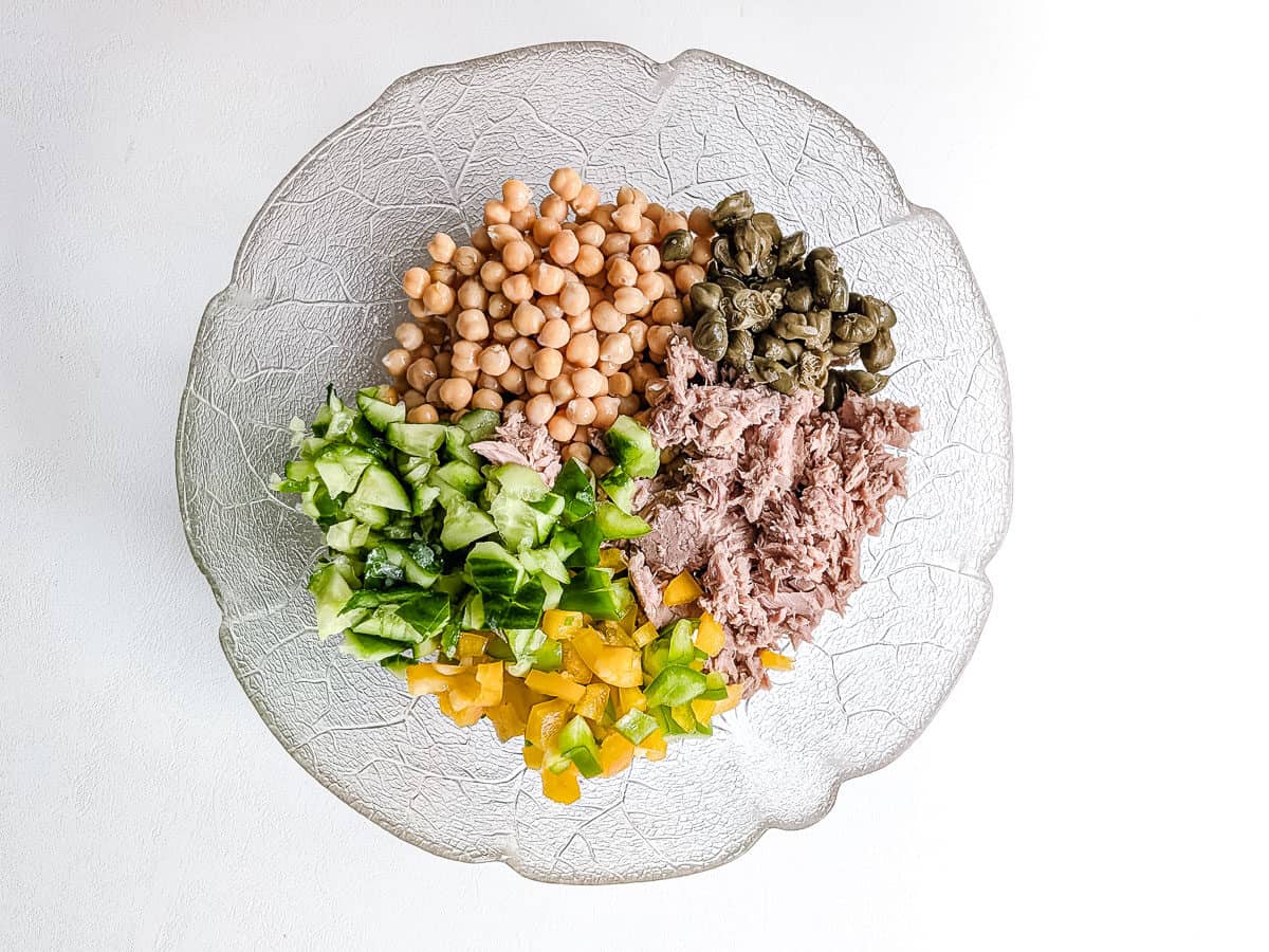 Combining the ingredients for chickpea tuna salad in a bowl.