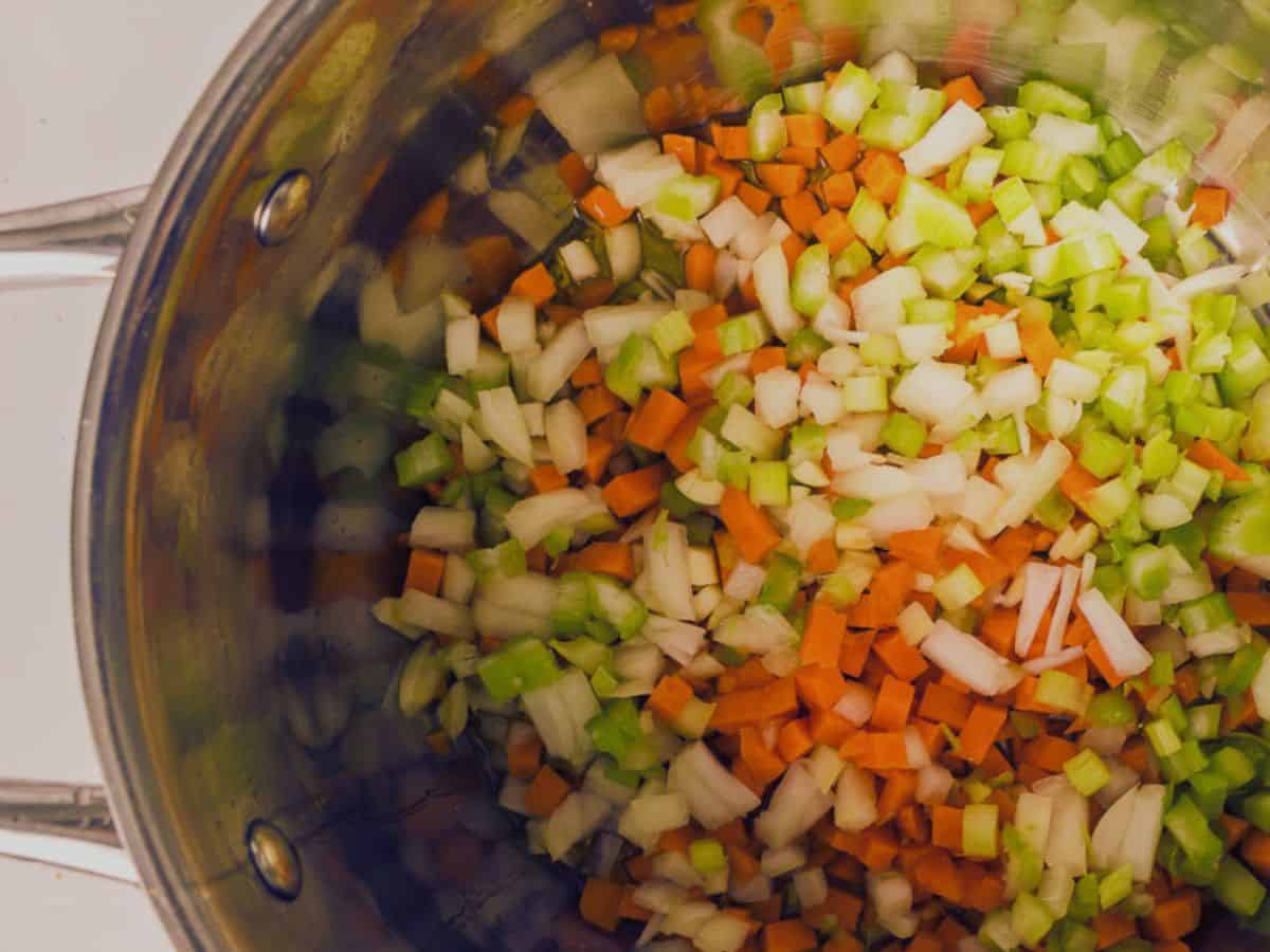 Diced carrots and celery inside a pot ready for cooking.
