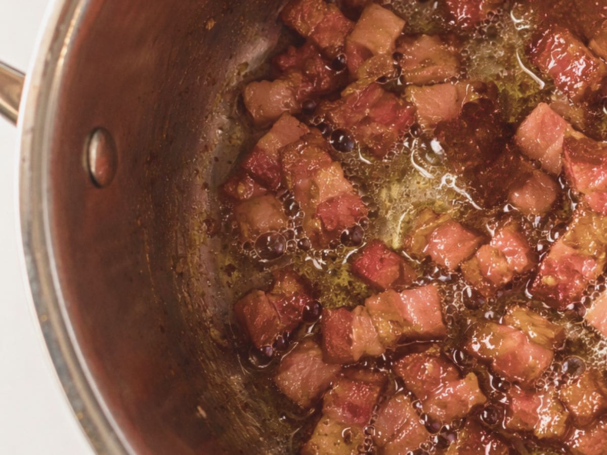 Bacon frying in a pot.