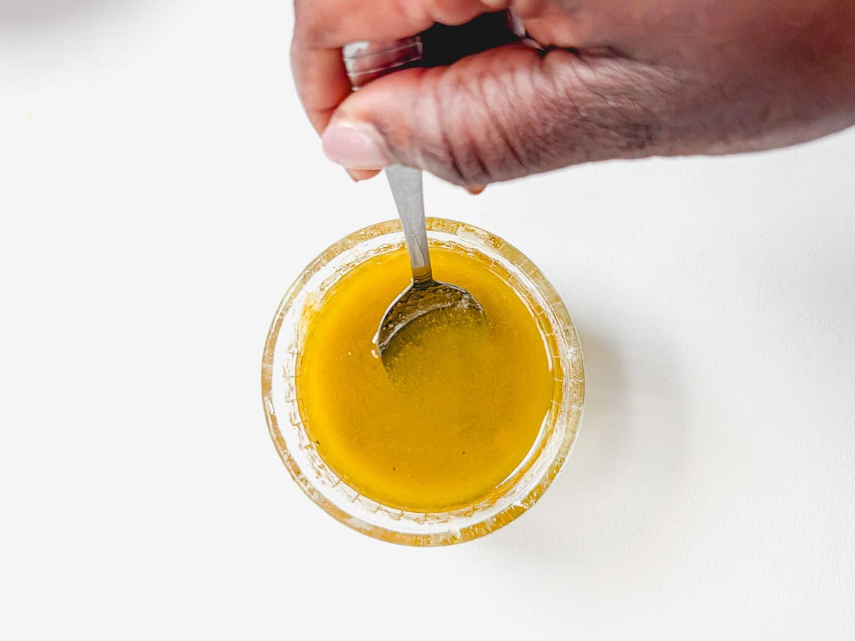 Mixing lemon olive oil dressing in a small bowl.