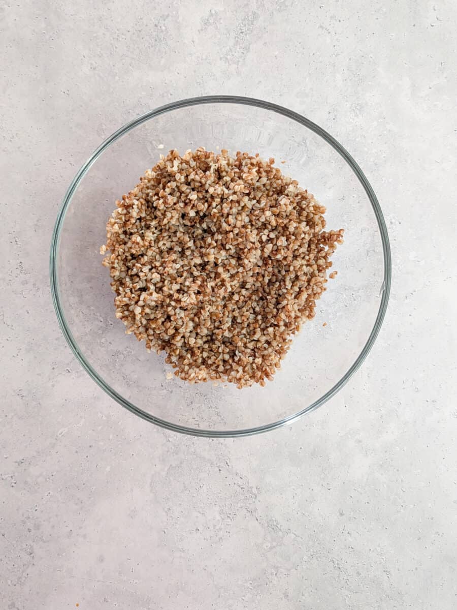 A close-up image of cooked buckwheat in a glass bowl.